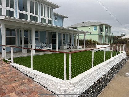Exterior renovation with custom cable railing and turf