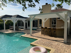 Outdoor living space with custom pergolas and pool by Demi Construction